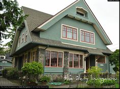 a green house with red trim and windows