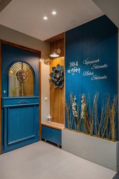 an entrance to a building with blue doors and flowers on the front door, next to a bench