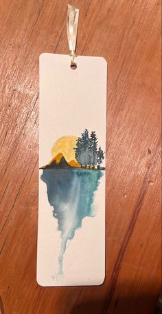 a watercolor painting of a lake with trees on it