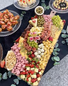 a table topped with lots of different types of food on plates and serving trays