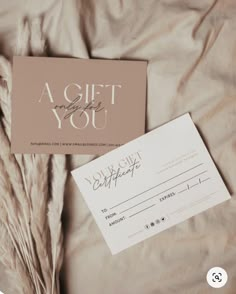 a gift card sitting on top of a bed next to some dry grass and a note