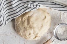 a ball of dough sitting on top of a table next to a measuring spoon