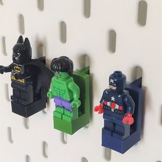 three lego batmans are hanging on the wall