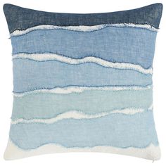 a blue and white striped pillow with fraying on the front, sitting against a white background