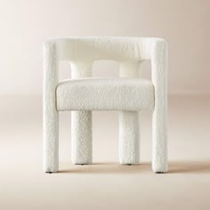 a white chair made out of fake sheep's wool with a rounded back and seat