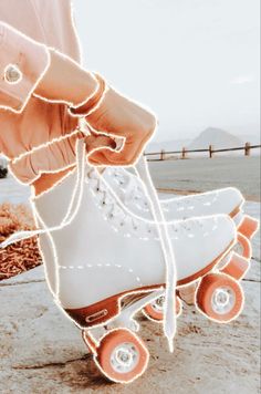 a pair of white roller skates with orange wheels