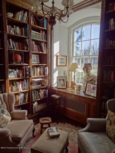 a living room filled with lots of furniture and bookshelves next to a window