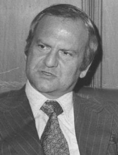 a man in a suit and tie sitting down