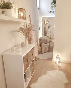 a hallway with white walls and wooden flooring next to a shelf filled with plants