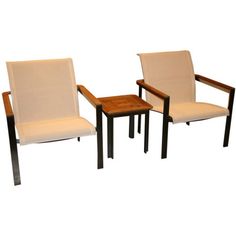 two chairs and a small table on a white background