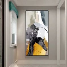 an abstract painting hangs in the corner of a room