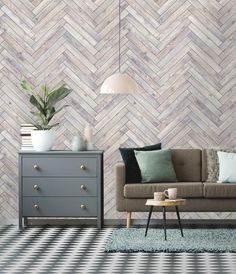 a living room with a couch, coffee table and lamp on the side wall next to a chest of drawers