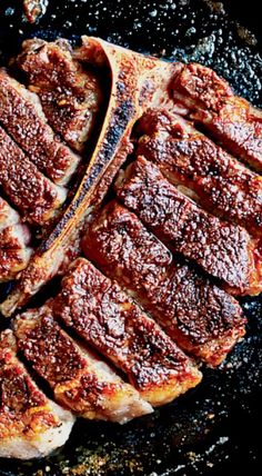 two pieces of meat sitting on top of a frying pan covered in bbq sauce