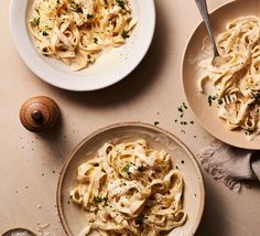 two bowls filled with pasta on top of a table