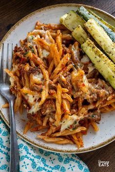 a white plate topped with pasta and zucchini