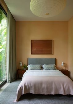 a bedroom with a bed, nightstands and large glass doors leading to the outside