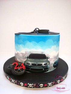 a car themed birthday cake with skulls on the front and side, sitting on top of a black plate