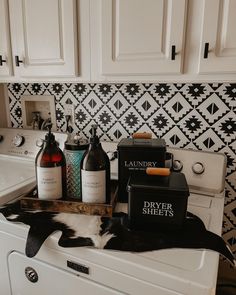 a white washer sitting in a bathroom next to a sink with bottles on it