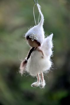 a white doll hanging from a string