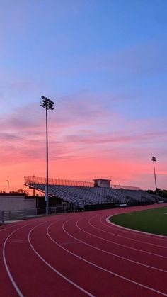 the sun is setting over an empty track