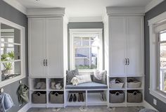 a white and gray laundry room with lots of storage