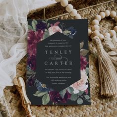 a wedding card with flowers on it next to some tassels and other accessories