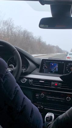 the interior of a car with dashboard, steering wheel and display screen showing an image of a person driving