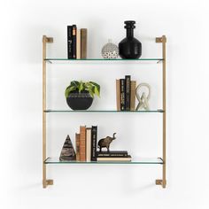 three shelves with books and vases on them