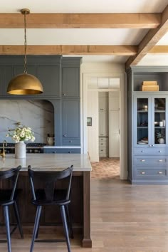 the kitchen is decorated in blue and white with gold accents, along with black bar stools