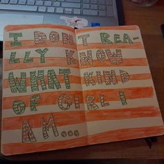 an open book sitting on top of a wooden desk next to a laptop and keyboard