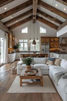 a living room filled with lots of furniture and wooden beams on the ceiling above it