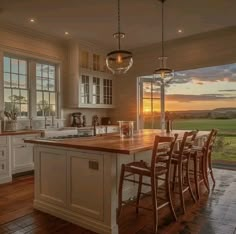 a large kitchen with an island in the middle and lots of windows on both sides