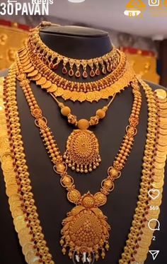 a gold necklace and earring set on display in a store window, with the price displayed