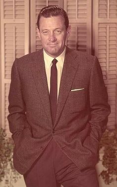 a man in a suit and tie posing for a photo