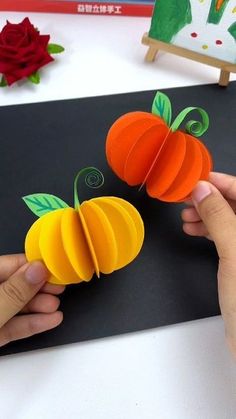 two paper pumpkins are being cut into pieces