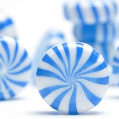 several blue and white candy canes on a white surface with one in the foreground