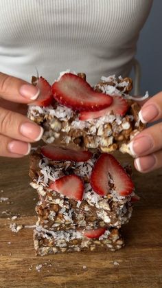 a woman holding two pieces of food on top of a wooden table with the words rice cake in front of her