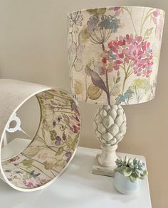 a table with a lamp and vase on it