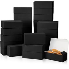 several black boxes are stacked on top of each other and one box has an orange sandwich in it