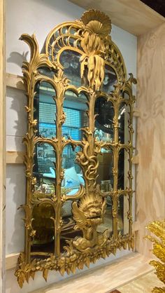 a gold mirror sitting on top of a wooden shelf