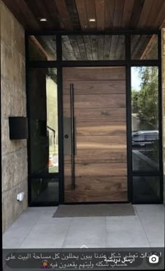 an entrance to a home with glass doors and wood paneling on the front door