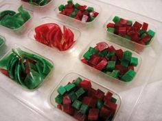 several plastic containers filled with red and green food items on top of a white table