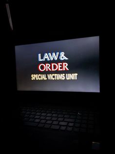 a laptop computer sitting on top of a desk in front of a sign that says law & order special victims unit