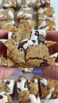 someone holding up a cookie bar with marshmallows and chocolate chips