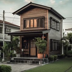 a wooden house with potted plants in the front yard