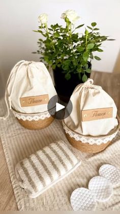 two white heart shaped cookies sitting on top of a table next to a potted plant