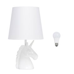 a lamp with a white unicorn head on it next to a light bulb