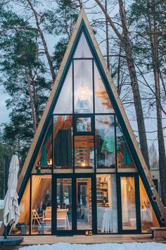 a - frame cabin in the woods with snow on the ground