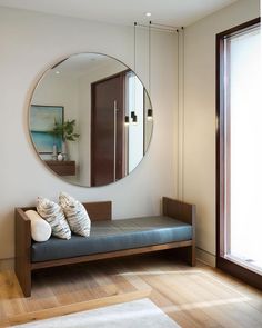 a living room with a couch, mirror and window