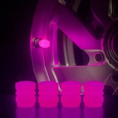 the wheels and rims of a car are lit up with purple light in this image